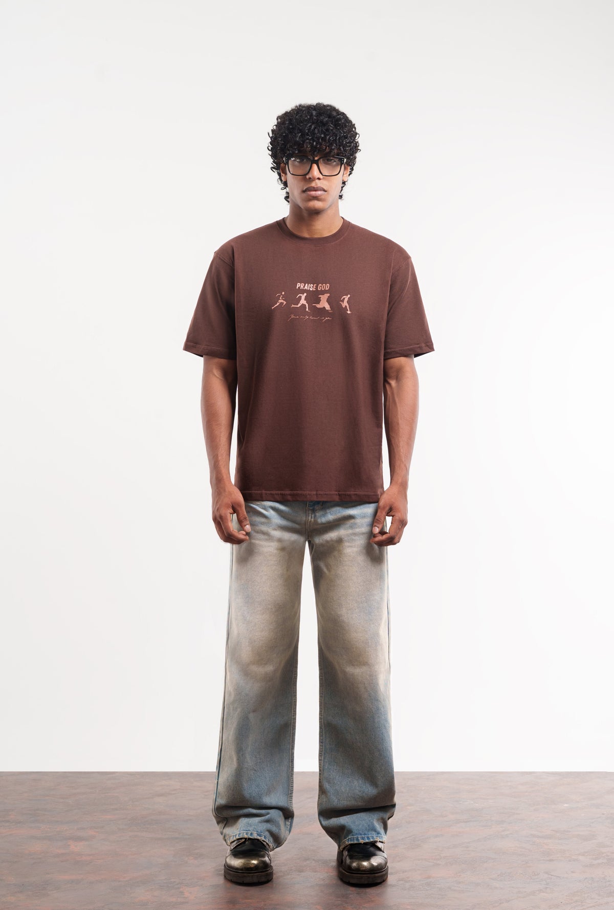 Model wearing brown graphic T-shirt by Praise God
